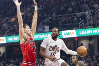 Dec 19, 2025; Cleveland, Ohio, USA; Cleveland Cavaliers guard Darius Garland (10) passes the ball past Chicago Bulls forward-center Zach Collins (12) during the first quarter at Rocket Arena. Mandatory Credit: Scott Galvin-Imagn Images