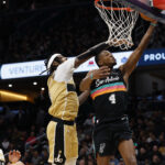 Dec 21, 2025; Washington, District of Columbia, USA; San Antonio Spurs guard De'Aaron Fox (4) shoots the ball as Washington Wizards guard Tre Johnson (12) defends in the first quarter at Capital One Arena. Mandatory Credit: Geoff Burke-Imagn Images