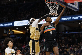 Dec 21, 2025; Washington, District of Columbia, USA; San Antonio Spurs guard De'Aaron Fox (4) shoots the ball as Washington Wizards guard Tre Johnson (12) defends in the first quarter at Capital One Arena. Mandatory Credit: Geoff Burke-Imagn Images