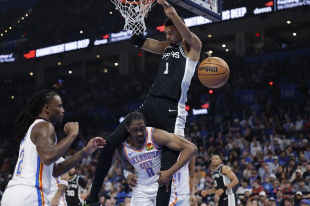 Dec 25, 2025; Oklahoma City, Oklahoma, USA; San Antonio Spurs forward Victor Wembanyama (1) dunks over Oklahoma City Thunder guard Jalen Williams (8) during the second quarter at Paycom Center. Mandatory Credit: Alonzo Adams-Imagn Images