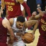 Jan 7, 2024; Cleveland, Ohio, USA; San Antonio Spurs center Victor Wembanyama (1) dribbles between Cleveland Cavaliers guard Max Strus (1) and guard Donovan Mitchell (45) in the fourth quarter at Rocket Mortgage FieldHouse. Mandatory Credit: David Richard-Imagn Images