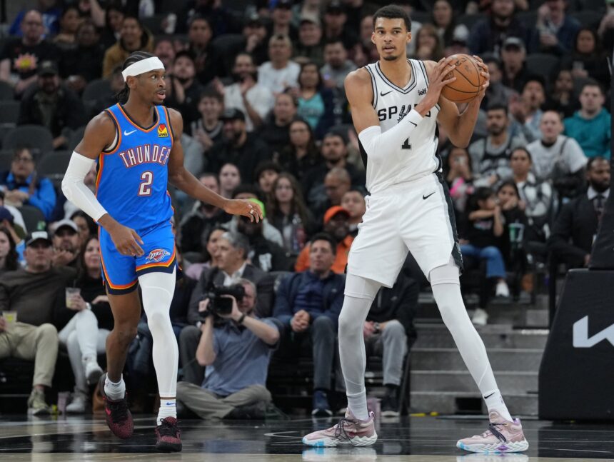 Feb 29, 2024; San Antonio, Texas, USA; San Antonio Spurs center Victor Wembanyama (1) looks down the court beside Oklahoma City Thunder guard Shai Gilgeous-Alexander (2) in the first half at Frost Bank Center. Mandatory Credit: Daniel Dunn-Imagn Images
