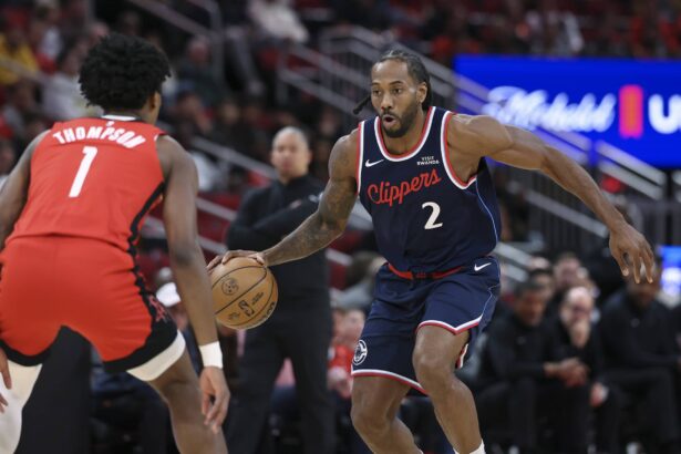 Houston, Texas, USA; Los Angeles Clippers forward Kawhi Leonard (2) dribbles the ball as Houston Rockets guard Amen Thompson (1) defends during the first quarter at Toyota Center. Mandatory Credit: Troy Taormina-Imagn Images