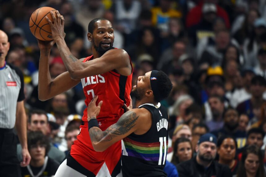 Denver, Colorado, USA; Houston Rockets forward Kevin Durant (7) holds the ball as he is defended by Denver Nuggets guard Bruce Brown (11) during the second half at Ball Arena. Mandatory Credit: Christopher Hanewinckel-Imagn Images