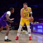 Los Angeles, California, USA; Los Angeles Lakers guard Luka Doncic (77) controls the ball against Phoenix Suns guard Jamaree Bouyea (17) during the second half at Crypto.com Arena. Mandatory Credit: Gary A. Vasquez-Imagn Images