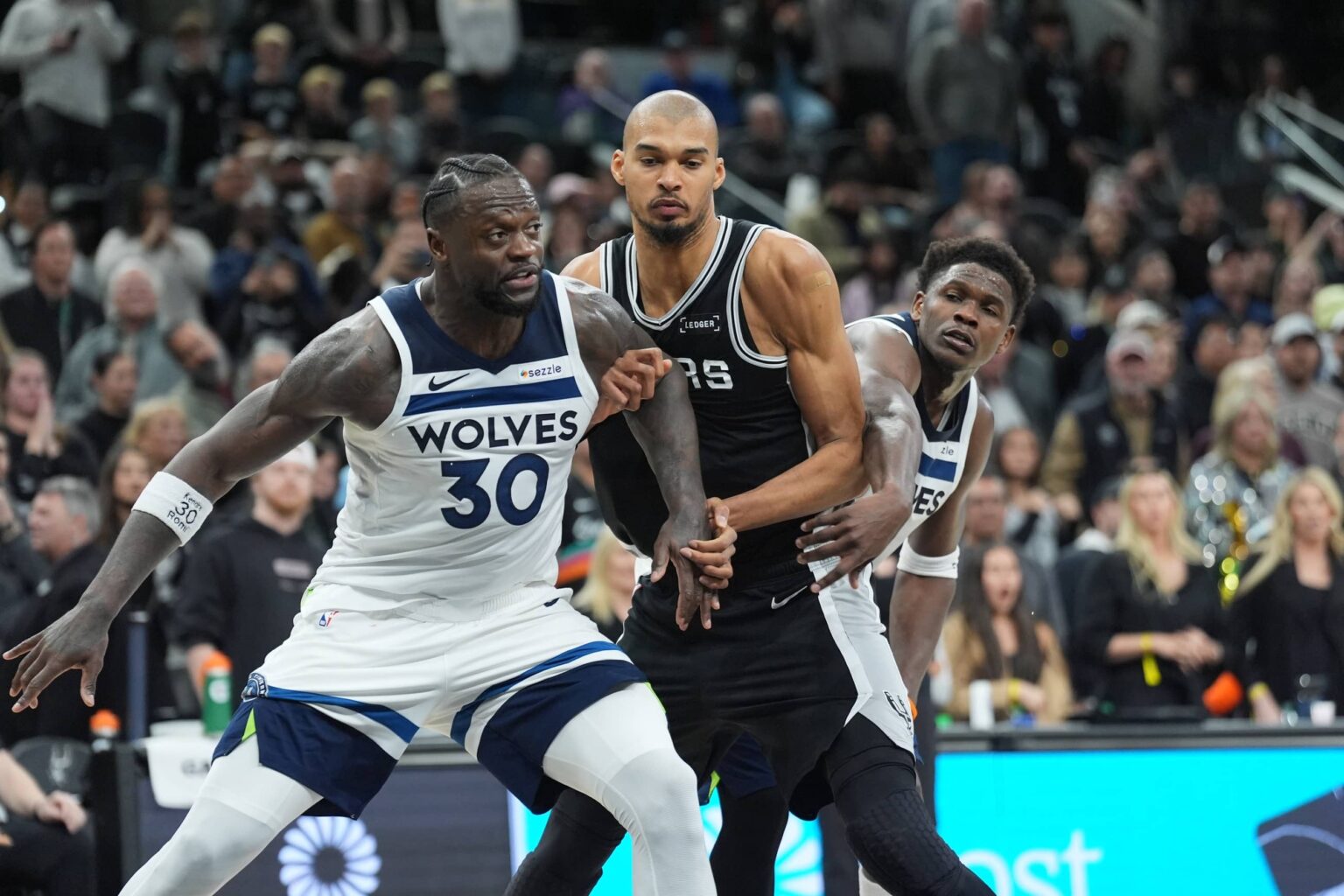 Minnesota Timberwolves forward Julius Randle (30) and guard Anthony Edwards (5) try to keep San Antonio Spurs forward Victor Wembanyama (1) from a rebound in the second half at Frost Bank Center.