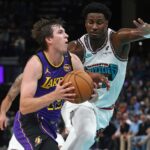 Nov 6, 2024; Memphis, Tennessee, USA; Los Angeles Lakers guard Austin Reaves (15) drives to the basket as Memphis Grizzlies forward Jaren Jackson Jr. (13) defends during the first half at FedExForum. Mandatory Credit: Petre Thomas-Imagn Images