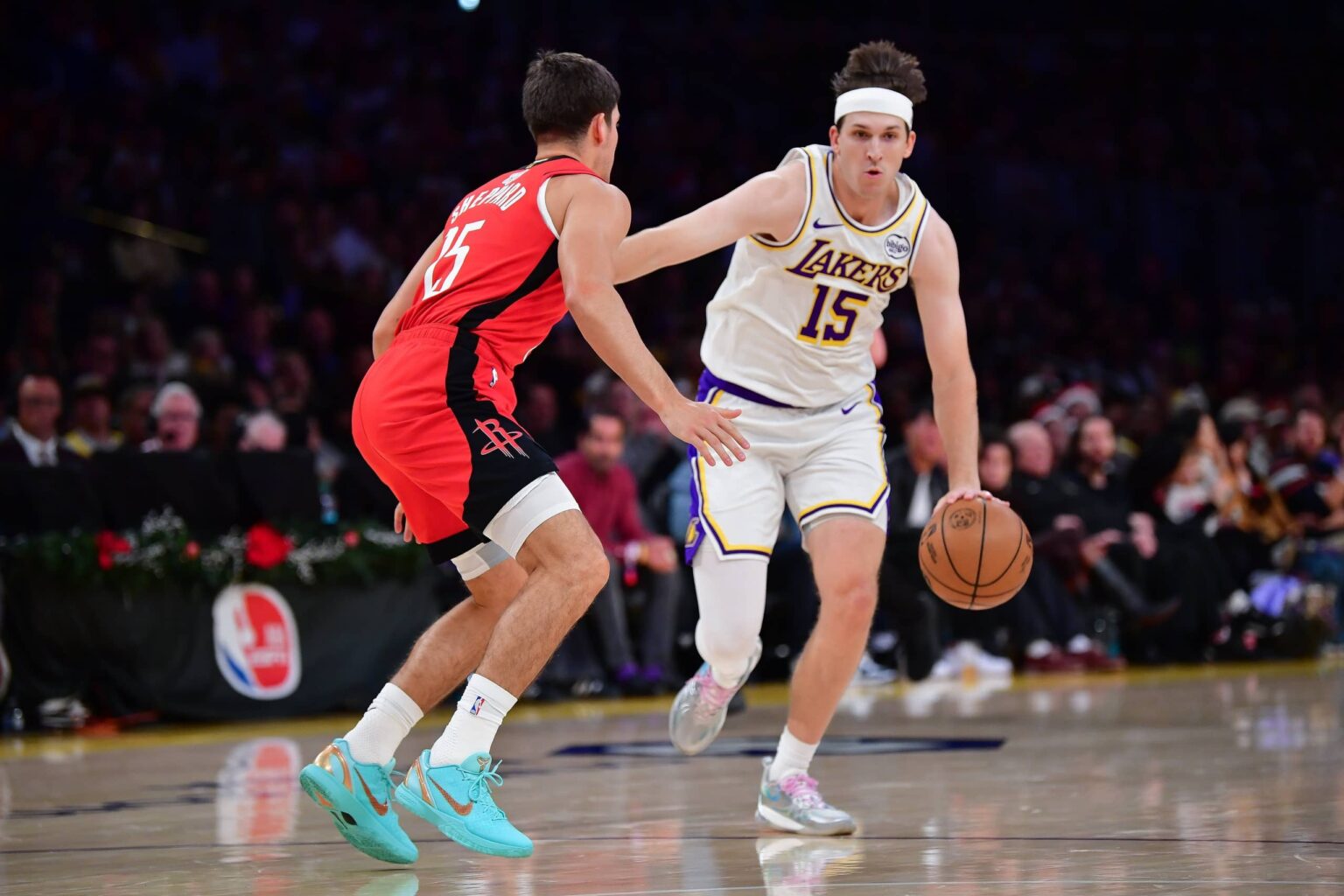 Dec 25, 2025; Los Angeles, California, USA; Los Angeles Lakers guard Austin Reaves (15) moves the ball against Houston Rockets guard Reed Sheppard (15) during the first half at Crypto.com Arena. Mandatory Credit: Gary A. Vasquez-Imagn Images