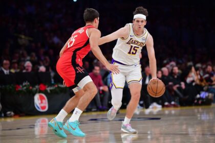 Dec 25, 2025; Los Angeles, California, USA; Los Angeles Lakers guard Austin Reaves (15) moves the ball against Houston Rockets guard Reed Sheppard (15) during the first half at Crypto.com Arena. Mandatory Credit: Gary A. Vasquez-Imagn Images
