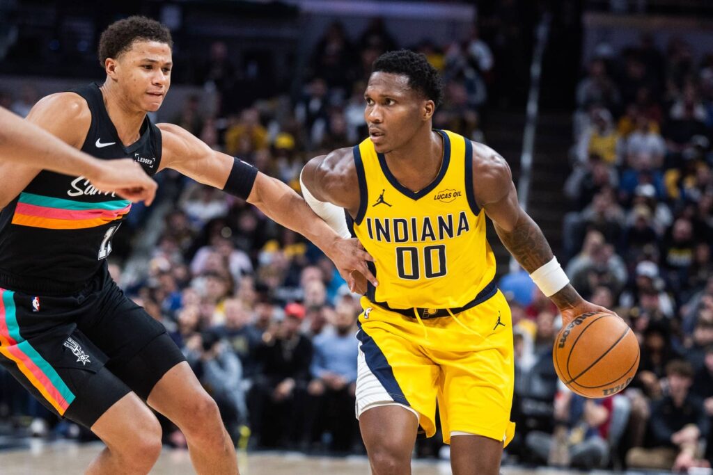 Indiana Pacers guard/forward Bennedict Mathurin (00) dribbles the ball while San Antonio Spurs forward Carter Bryant (11) defends in the first half at Gainbridge Fieldhouse.