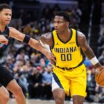 Indiana Pacers guard/forward Bennedict Mathurin (00) dribbles the ball while San Antonio Spurs forward Carter Bryant (11) defends in the first half at Gainbridge Fieldhouse.