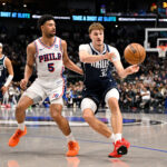 Jan 1, 2026; Dallas, Texas, USA; Dallas Mavericks forward Cooper Flagg (32) passes the ball by Philadelphia 76ers guard Quentin Grimes (5) during the second quarter at the American Airlines Center. Mandatory Credit: Jerome Miron-Imagn Images
