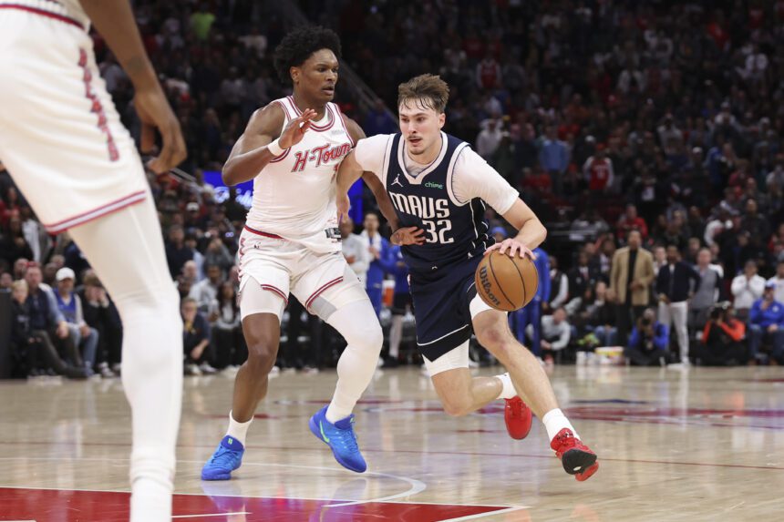 Jan 31, 2026; Houston, Texas, USA; Dallas Mavericks forward Cooper Flagg (32) drives with the ball as Houston Rockets guard Amen Thompson (1) defends during the fourth quarter at Toyota Center. Mandatory Credit: Troy Taormina-Imagn Images