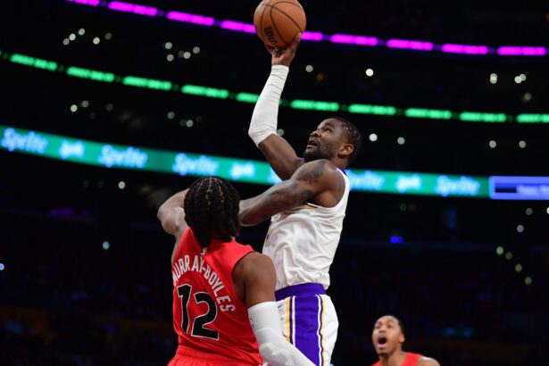 Jan 18, 2026; Los Angeles, California, USA; Los Angeles Lakers center Deandre Ayton (5) shoots against Toronto Raptors forward Collin Murray-Boyles (12) during the first half at Crypto.com Arena. Mandatory Credit: Gary A. Vasquez-Imagn Images