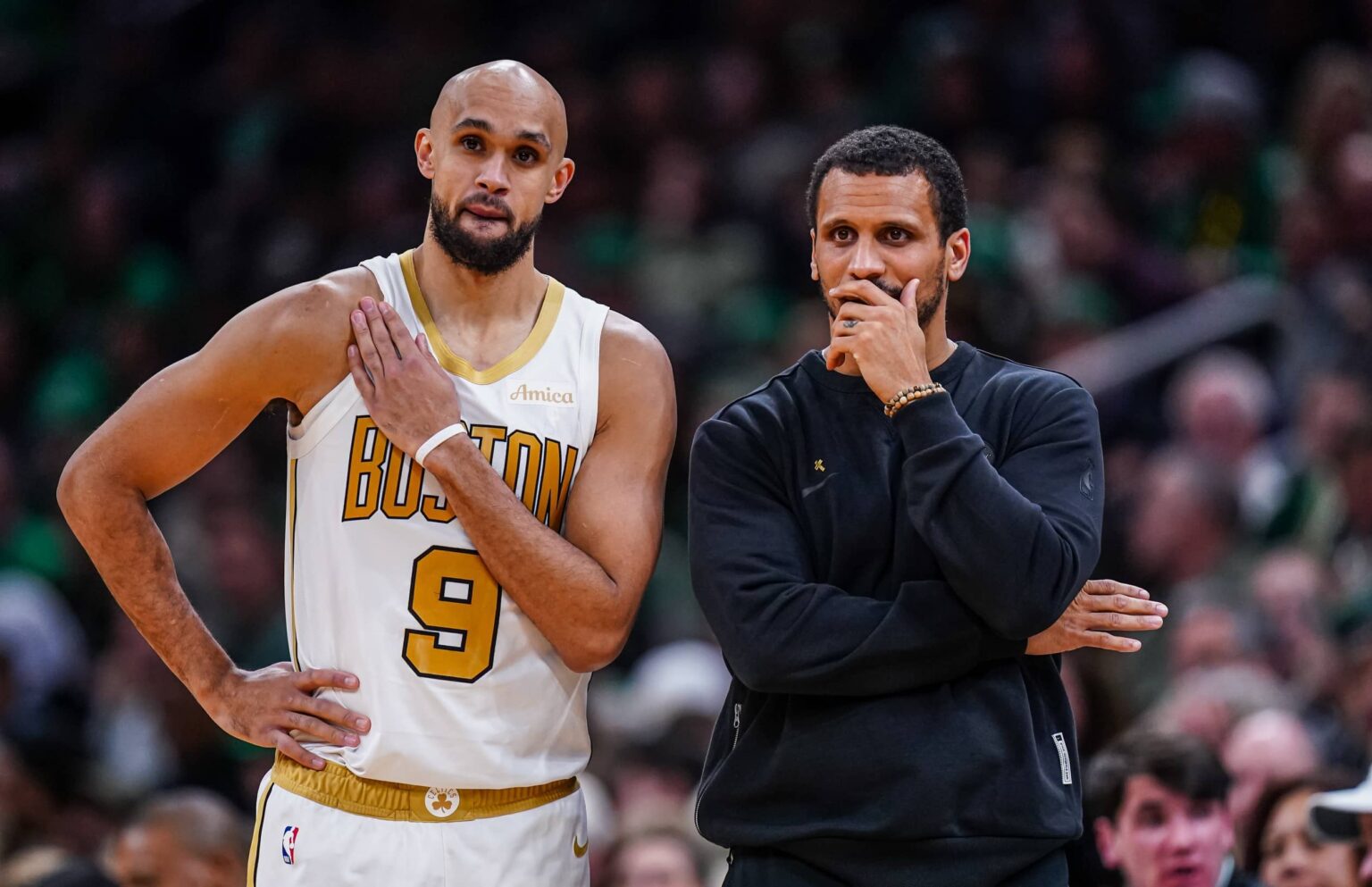 Boston Celtics head coach Joe Mazzulla talks with guard Derrick White (9) from the sideline as they take on the Miami Heat at TD Garden.