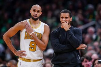 Boston Celtics head coach Joe Mazzulla talks with guard Derrick White (9) from the sideline as they take on the Miami Heat at TD Garden.