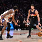 Phoenix Suns guard Devin Booker (1) sets the play while defended by New York Knicks center Mitchell Robinson (23) during the second half at Madison Square Garden.
