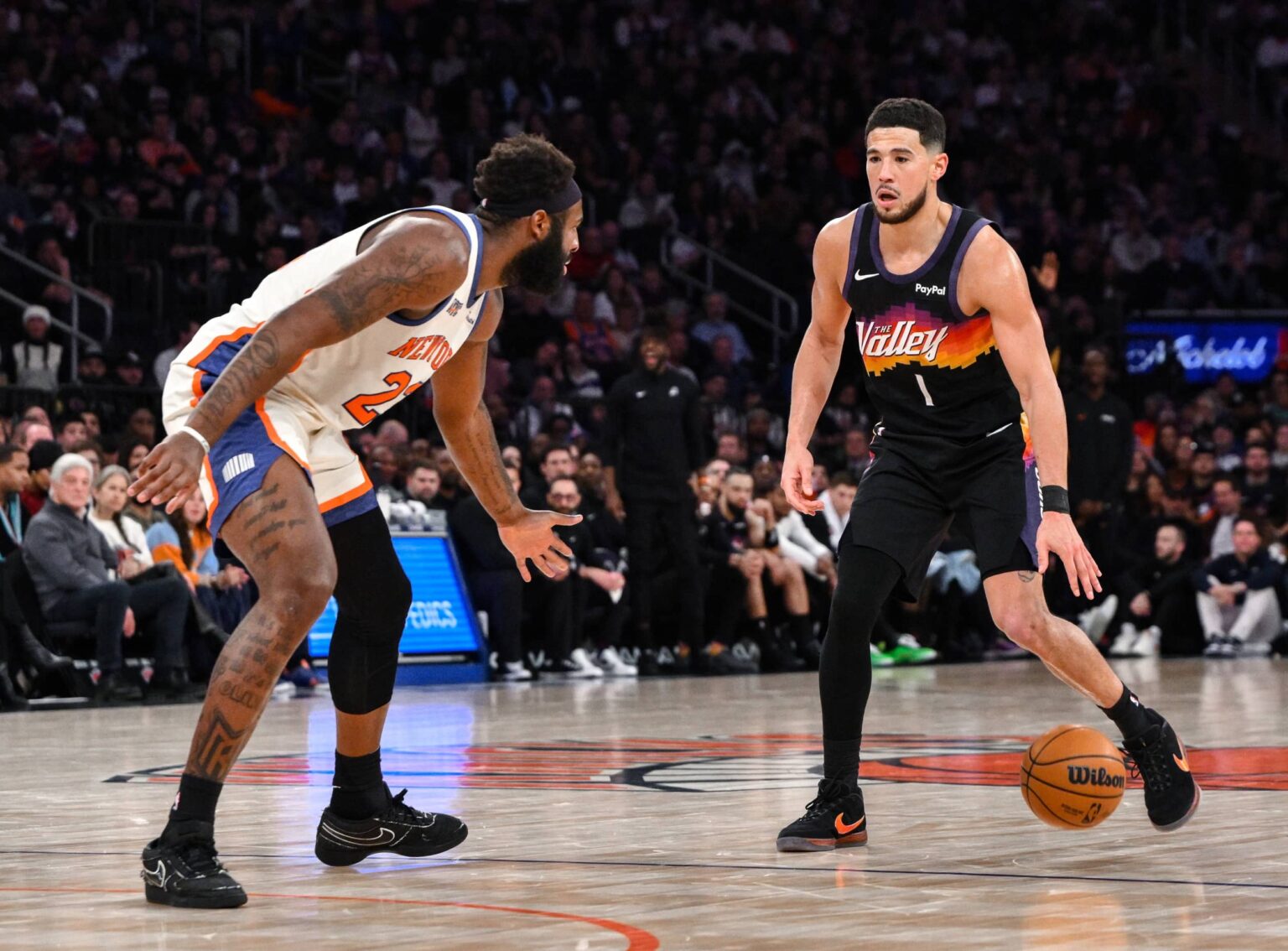 Phoenix Suns guard Devin Booker (1) sets the play while defended by New York Knicks center Mitchell Robinson (23) during the second half at Madison Square Garden.