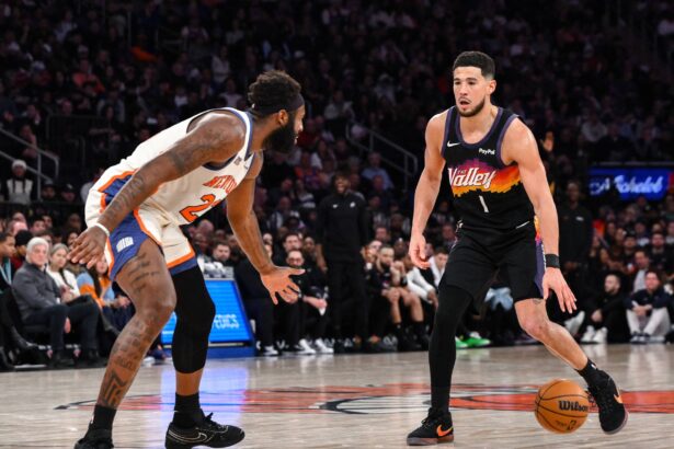 Phoenix Suns guard Devin Booker (1) sets the play while defended by New York Knicks center Mitchell Robinson (23) during the second half at Madison Square Garden.