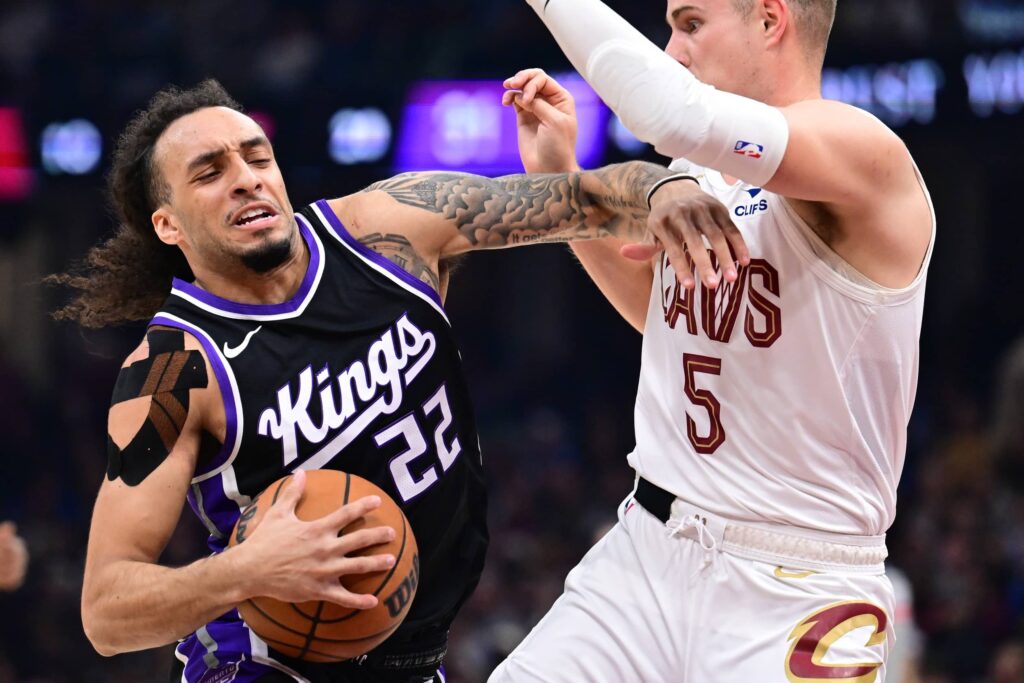Apr 6, 2025; Cleveland, Ohio, USA; Sacramento Kings guard Devin Carter (22) drives to the basket against Cleveland Cavaliers guard Sam Merrill (5) during the first half at Rocket Arena. Mandatory Credit: Ken Blaze-Imagn Images