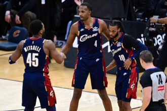 Jan 2, 2026; Cleveland, Ohio, USA; Cleveland Cavaliers center Evan Mobley (4) congratulates guard Donovan Mitchell (45) and guard Darius Garland (10) after the Cavaliers defeated the Denver Nuggets at Rocket Arena. Mandatory Credit: David Dermer-Imagn Images