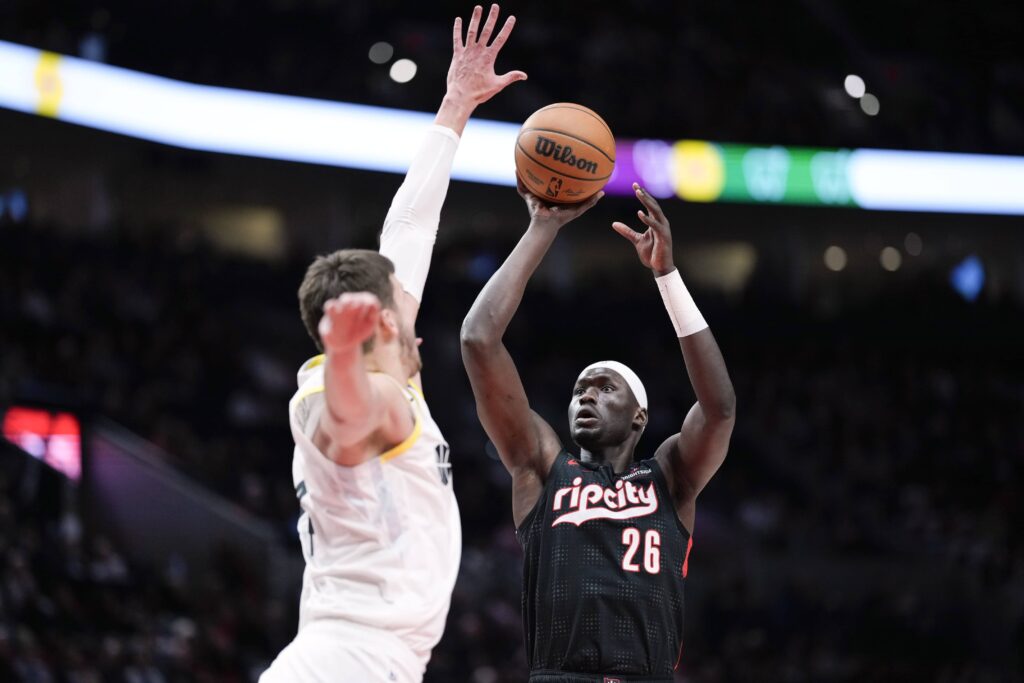 Dec 6, 2024; Portland, Oregon, USA; Portland Trail Blazers center Duop Reath (26) shoots the ball over Utah Jazz center Walker Kessler (24) during the first half at Moda Center. Mandatory Credit: Soobum Im-Imagn Images