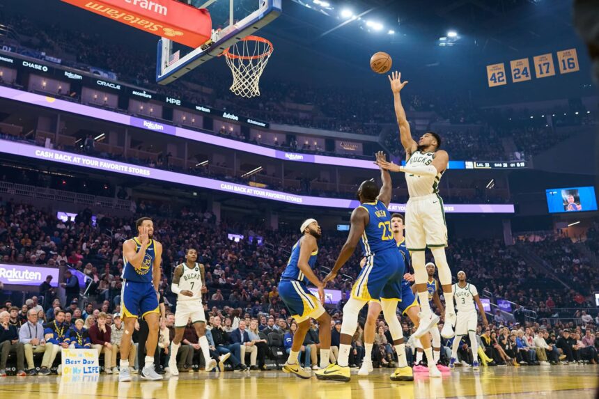 Jan 7, 2026; San Francisco, California, USA; Milwaukee Bucks forward Giannis Antetokounmpo (34) shoots the ball against Golden State Warriors guard Stephen Curry (30), guard Moses Moody (4) and forward Draymond Green (23) during the first quarter at Chase Center. Mandatory Credit: Robert Edwards-Imagn Images