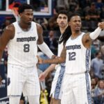 Dec 26, 2025; Memphis, Tennessee, USA; Memphis Grizzlies guard Ja Morant (12) reacts with forward/center Jaren Jackson Jr. (8) during the fourth quarter against the Milwaukee Bucks at FedExForum. Mandatory Credit: Petre Thomas-Imagn Images