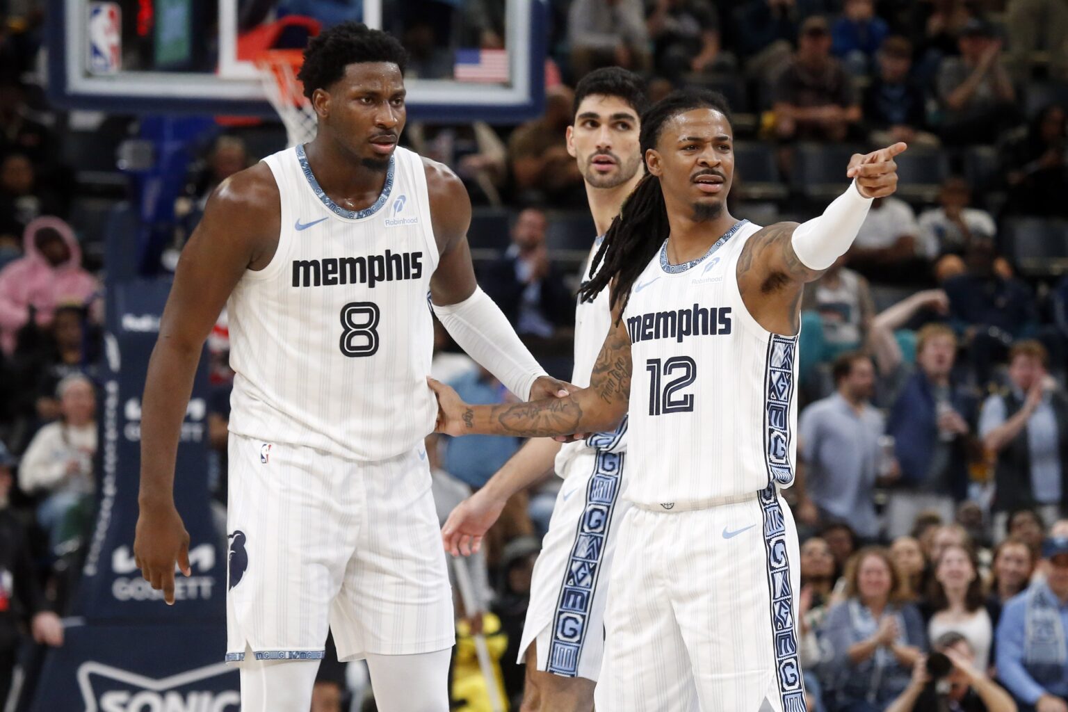Dec 26, 2025; Memphis, Tennessee, USA; Memphis Grizzlies guard Ja Morant (12) reacts with forward/center Jaren Jackson Jr. (8) during the fourth quarter against the Milwaukee Bucks at FedExForum. Mandatory Credit: Petre Thomas-Imagn Images