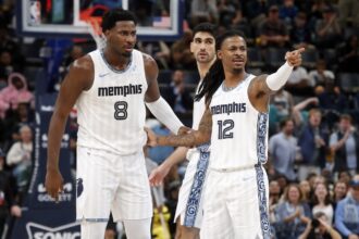 Dec 26, 2025; Memphis, Tennessee, USA; Memphis Grizzlies guard Ja Morant (12) reacts with forward/center Jaren Jackson Jr. (8) during the fourth quarter against the Milwaukee Bucks at FedExForum. Mandatory Credit: Petre Thomas-Imagn Images