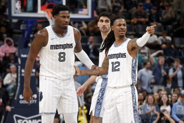 Dec 26, 2025; Memphis, Tennessee, USA; Memphis Grizzlies guard Ja Morant (12) reacts with forward/center Jaren Jackson Jr. (8) during the fourth quarter against the Milwaukee Bucks at FedExForum. Mandatory Credit: Petre Thomas-Imagn Images