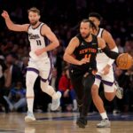 Jan 27, 2026; New York, New York, USA; New York Knicks guard Jalen Brunson (11) brings the ball up court against Sacramento Kings center Dylan Cardwell (32) and forward Domantas Sabonis (11) during the first quarter at Madison Square Garden. Mandatory Credit: Brad Penner-Imagn Images