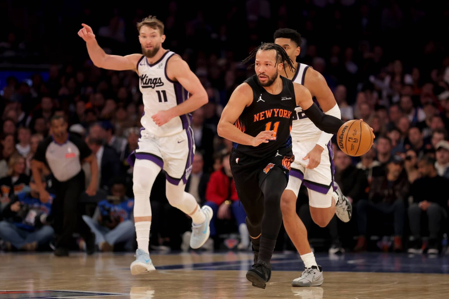 Jan 27, 2026; New York, New York, USA; New York Knicks guard Jalen Brunson (11) brings the ball up court against Sacramento Kings center Dylan Cardwell (32) and forward Domantas Sabonis (11) during the first quarter at Madison Square Garden. Mandatory Credit: Brad Penner-Imagn Images