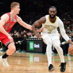 Jan 5, 2026; Boston, Massachusetts, USA; Boston Celtics guard Jaylen Brown (7) controls the ball while Chicago Bulls guard Kevin Huerter (13) defends during the first half at TD Garden. Mandatory Credit: Bob DeChiara-Imagn Images