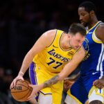 Oct 21, 2025; Los Angeles, California, USA; Los Angeles Lakers guard Luka Doncic (77) looks to drive against Golden State Warriors forward Jonathan Kuminga (1) during the second half at Crypto.com Arena. Mandatory Credit: William Liang-Imagn Images