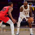 Los Angeles Lakers forward LeBron James (23) controls the ball against Toronto Raptors guard Ochai Agbaji (30) during the first half at Crypto.com Arena.