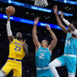 Jan 15, 2026; Los Angeles, California, USA; Los Angeles Lakers forward LeBron James (23) shoots the ball against Charlotte Hornets forward Grant Williams (2) and forward Brandon Miller (24) in the first half at Crypto.com Arena. Mandatory Credit: Kirby Lee-Imagn Images