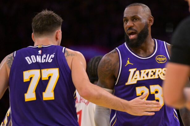Los Angeles Lakers guard Luka Doncic (77) and forward LeBron James (23) react after a foul during the first half against the Los Angeles Clippers at Crypto.com Arena.