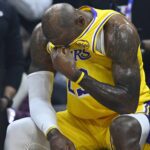 Jan 28, 2026; Cleveland, Ohio, USA; Los Angeles Lakers forward LeBron James (23) reacts on the bench during a video tribute shown on the scoreboard during a timeout in the first quarter against the Cleveland Cavaliers at Rocket Arena. Mandatory Credit: David Richard-Imagn Images