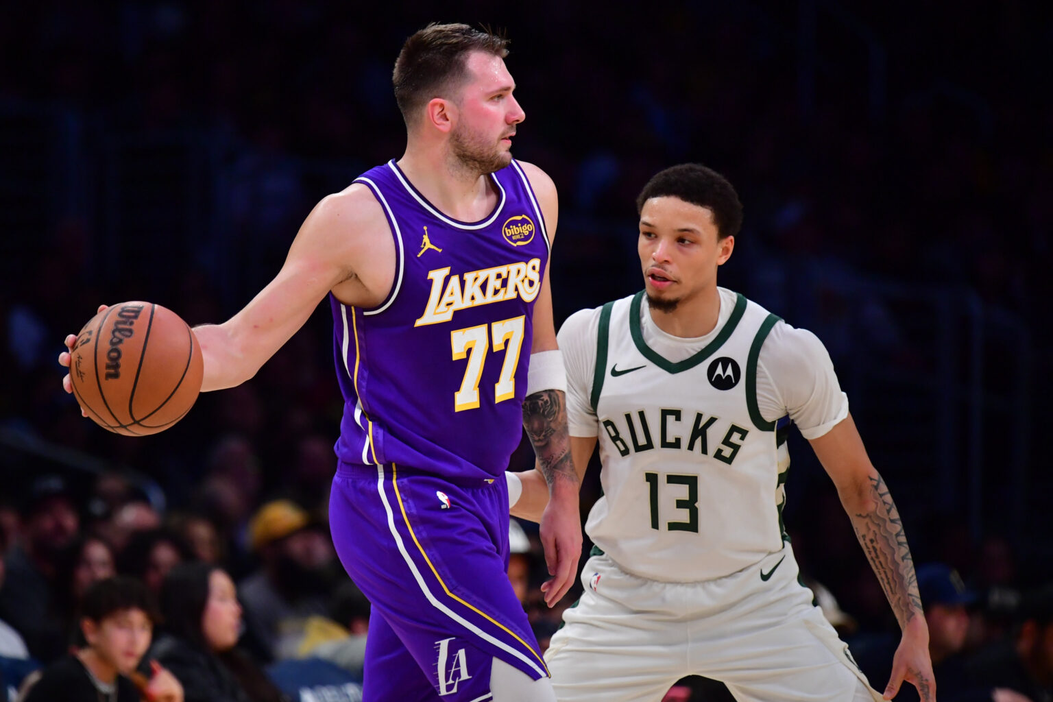 Jan 9, 2026; Los Angeles, California, USA; Los Angeles Lakers guard Luka Doncic (77) moves the ball against Milwaukee Bucks guard Ryan Rollins (13) during the first half at Crypto.com Arena. Mandatory Credit: Gary A. Vasquez-Imagn Images
