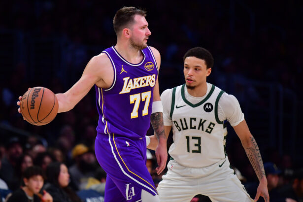 Jan 9, 2026; Los Angeles, California, USA; Los Angeles Lakers guard Luka Doncic (77) moves the ball against Milwaukee Bucks guard Ryan Rollins (13) during the first half at Crypto.com Arena. Mandatory Credit: Gary A. Vasquez-Imagn Images