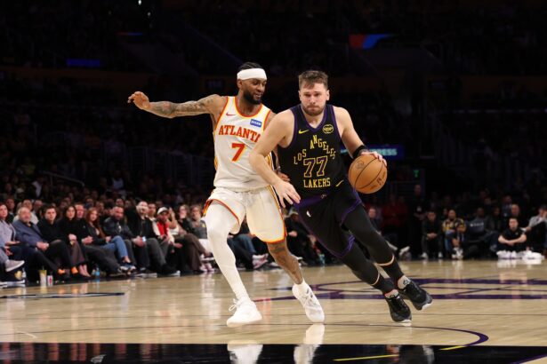 Jan 13, 2026; Los Angeles, California, USA; Los Angeles Lakers guard Luka Doncic (77) drives to the basket against Atlanta Hawks guard Nickeil Alexander-Walker (7) during the fourth quarter at Crypto.com Arena. Mandatory Credit: Kiyoshi Mio-Imagn Images