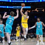Jan 15, 2026; Los Angeles, California, USA; Los Angeles Lakers guard Luka Doncic (77) shoots the ball against Charlotte Hornets guard Kon Knueppel (7) and forward Miles Bridges (0) in the first half at Crypto.com Arena. Mandatory Credit: Kirby Lee-Imagn Images