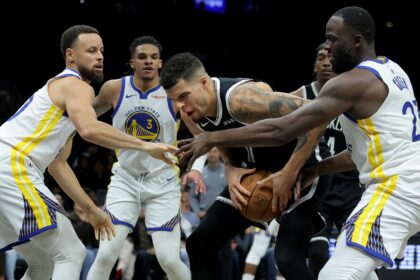 Dec 29, 2025; Brooklyn, New York, USA; Brooklyn Nets forward Michael Porter Jr. (17) grabs a rebound against Golden State Warriors guards Stephen Curry (30) and Will Richard (3) and forward Draymond Green (23) during the fourth quarter at Barclays Center. Mandatory Credit: Brad Penner-Imagn Images
