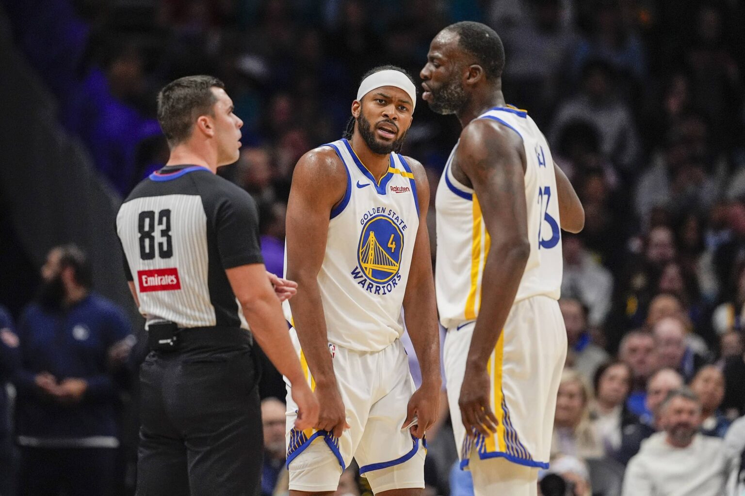 Golden State Warriors forward Draymond Green (23) reacts to a call with referee Andy Nagy (83) with guard Moses Moody (4) listening in during the second quarter against the Charlotte Hornets at Spectrum Center.