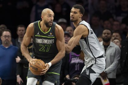 Jan 11, 2026; Minneapolis, Minnesota, USA; Minnesota Timberwolves center Rudy Gobert (27) holds the ball as San Antonio Spurs forward Victor Wembanyama (1) plays defense in the first half at Target Center. Mandatory Credit: Jesse Johnson-Imagn Images