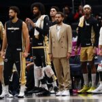 Jan 9, 2026; Washington, District of Columbia, USA; Newly acquired Washington Wizards guard Trae Young (M) looks on from the bench with teammates against the New Orleans Pelicans in the first half at Capital One Arena. Mandatory Credit: Geoff Burke-Imagn Images