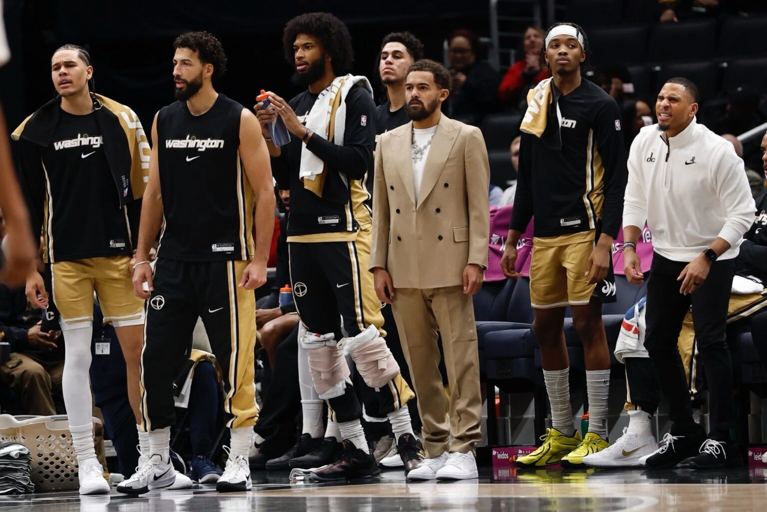 Jan 9, 2026; Washington, District of Columbia, USA; Newly acquired Washington Wizards guard Trae Young (M) looks on from the bench with teammates against the New Orleans Pelicans in the first half at Capital One Arena. Mandatory Credit: Geoff Burke-Imagn Images