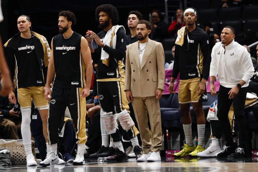 Jan 9, 2026; Washington, District of Columbia, USA; Newly acquired Washington Wizards guard Trae Young (M) looks on from the bench with teammates against the New Orleans Pelicans in the first half at Capital One Arena. Mandatory Credit: Geoff Burke-Imagn Images