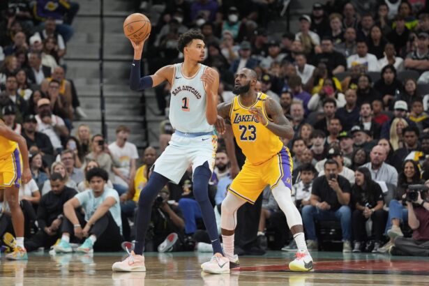 San Antonio Spurs center Victor Wembanyama (1) handles the ball in front of Los Angeles Lakers forward LeBron James (23) in the second half at Frost Bank Center.